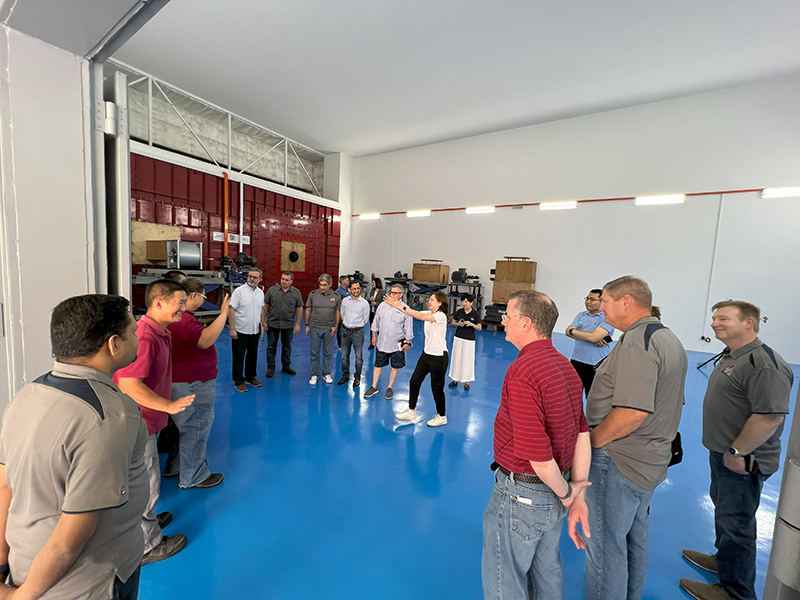 Ms. Tan Tin Tin, technical director, Asia AMCA, (center, gesturing) leads members of the AMCA staff and board of directors on a tour of the Asia AMCA laboratory March 22.